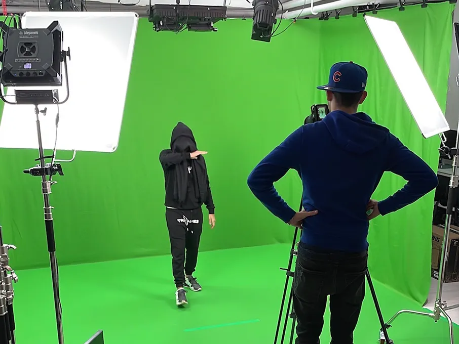 Set green screen: soggetto sul limbo verde durante una ripresa, con softbox e camera in regia di fronte
